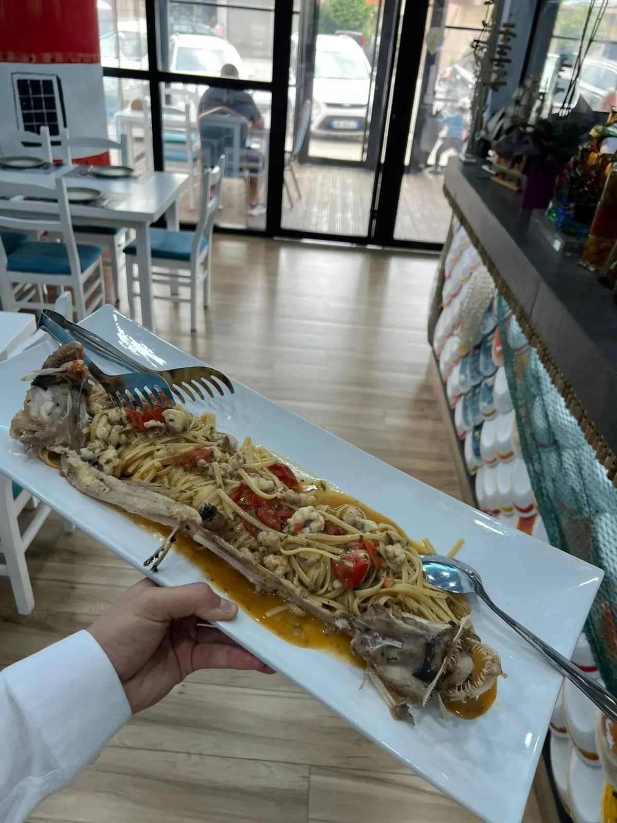 Pjatë me spageti dhe fruta deti në sallën e restorantit