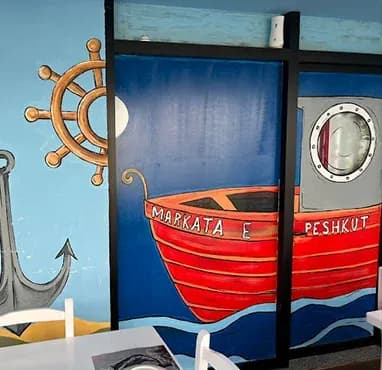 Mural me varkë dhe timon anijeje në ambientin e Markatës së Peshkut Astir në Tiranë